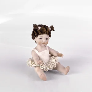 Statua in porcellana di una bimba in tutù da ballerina in pizzo e capelli in due codine alte con fiocchi bianchi.
