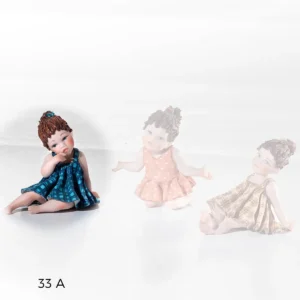 Statua in porcellana raffigurante una bimba seduta in abito blu.