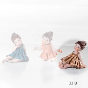 Statua in porcellana raffigurante una bimba seduta in abito giallo.