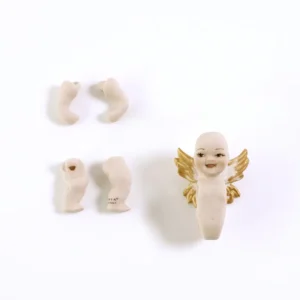 Bambolina in porcellana biscuit raffigurante un piccolo angioletto sorridente con ali bianche dalle punte dorate.
