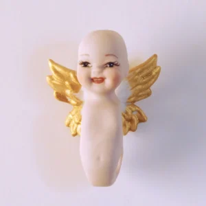 Bambolina in porcellana biscuit raffigurante un piccolo angioletto sorridente con ali bianche e punte dorate.
