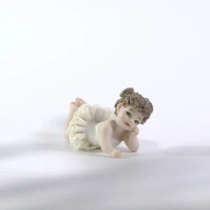 Statua in porcellana Ada Petipa, bimba ballerina in tutù di pizzo stesa a terra sulla pancia con due codine alte.