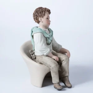Statua in porcellana Alan: ragazzo con camicia bianca e maglioncino azzurro seduto su poltrona bianca.