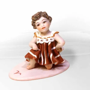 Statua in porcellana mini Ariete di Sibania con mantello e abito rosso in pizzo, dettagli dorati e base rossa col simbolo.