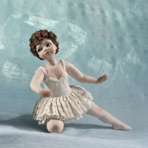 Statua in porcellana di ragazza in tutù da ballerina in pizzo, appoggiata su un ginocchio e con fiocco bianco nei capelli.
