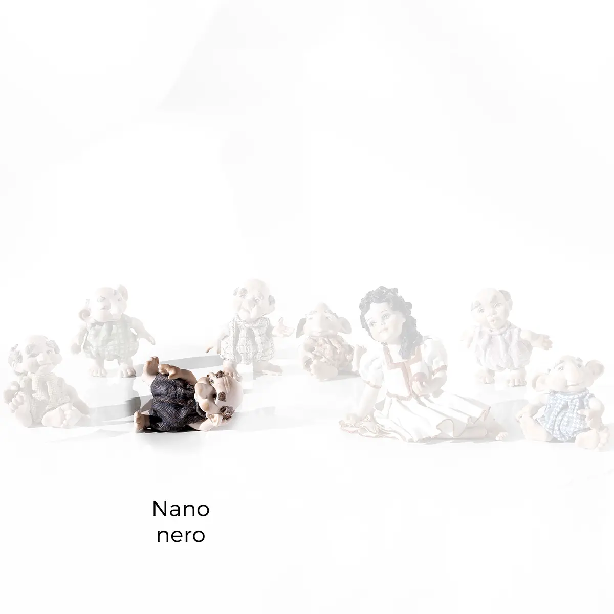 Statua in porcellana del Nano Nero con capelli rossicci e occhi verdi, steso a terra.
