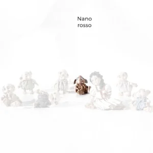 Statua in porcellana del Nano Rosso con capelli bianchi, seduto a terra mentre si guarda attorno confuso.