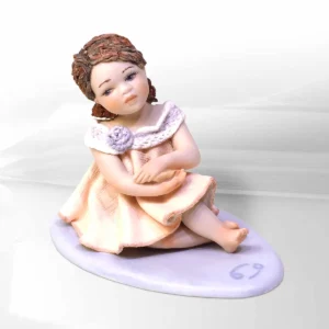 Statua mini Cancro di Sibania in abito bianco e rosa tenue con dettagli in tulle, code rosse e base viola.