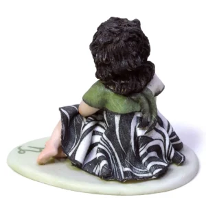 Mini statua in porcellana del Capricorno di Sibania con abito nero e verde scuro su base verde.