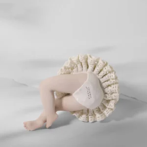 Statua in porcellana di bimba ballerina in tutù di pizzo, seduta a terra col viso su una mano e fiocco nei capelli.