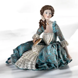 Statua in porcellana di dama veneziana del '700 seduta a terra, in abito azzurro con dettagli in pizzo e ventaglio ocra.
