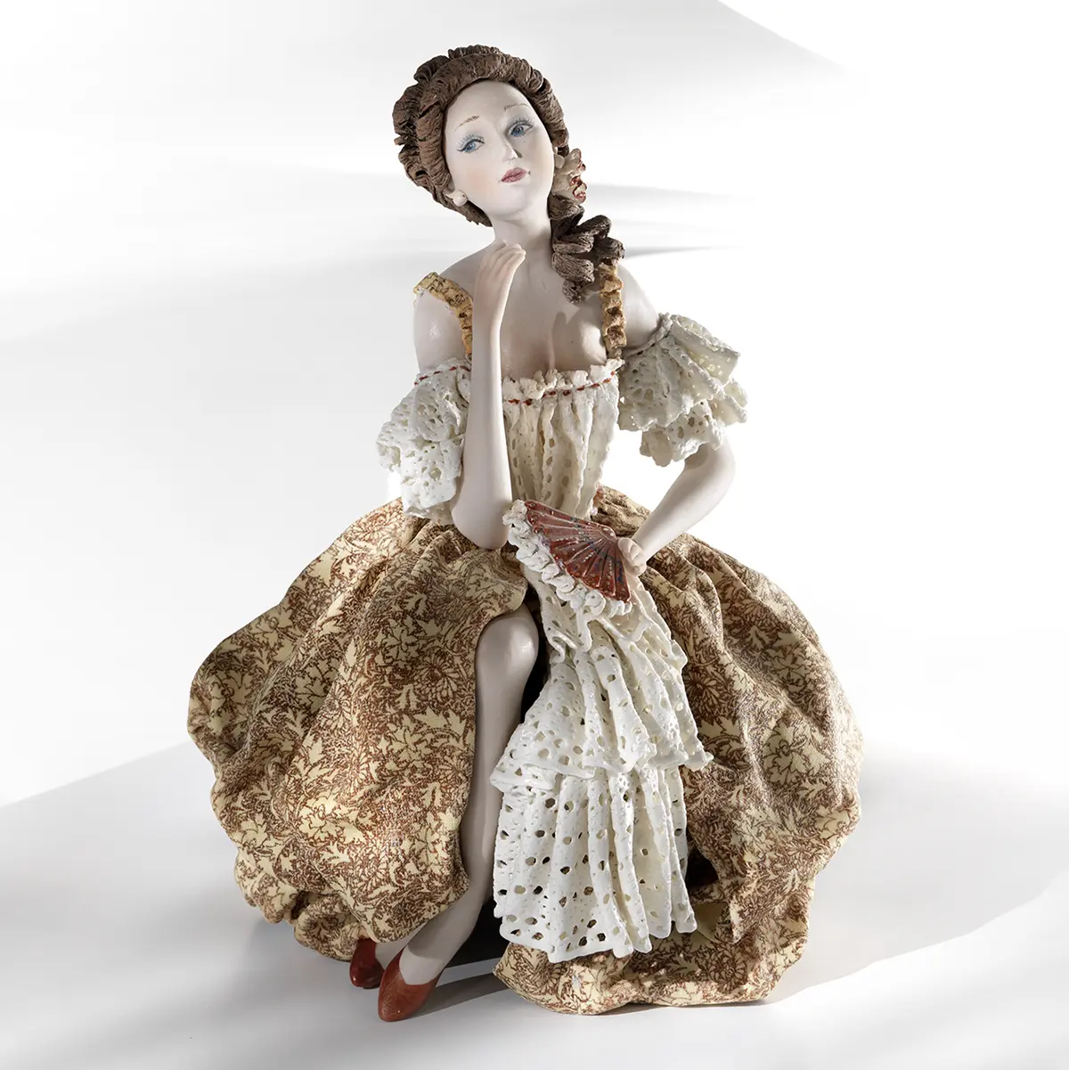 Statua in porcellana di dama veneziana del '700 in abito giallo e pizzo, seduta su balaustra con ventaglio.