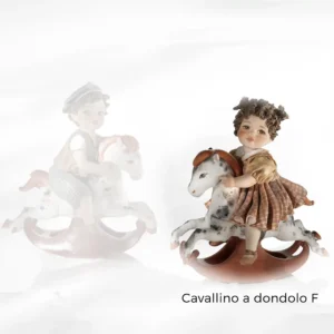 Statua in porcellana con bimba su cavallino a dondolo, vestito rosa a quadretti, camicetta bianca e codine.