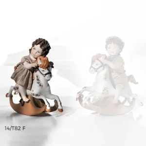 Statua in porcellana di bimba su cavallino a dondolo, abito a quadretti marroni e cavallo dalla criniera rossa.