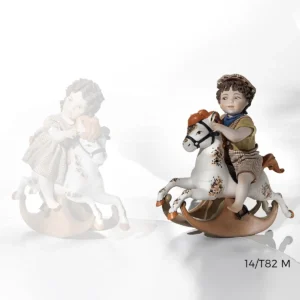 Statua in porcellana con bimbo su cavallino a dondolo, salopette a quadretti, maglia senape e bandana blu.
