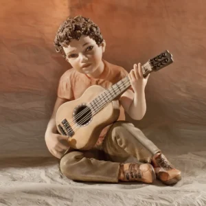 Statua in porcellana di ragazzo in t-shirt salmone e pantaloni marroncini che suona la chitarra.