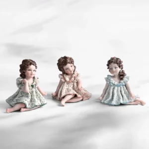 Statua in porcellana di bimba con abito in pizzo bianco e verde, fiocco sul petto e capelli raccolti in due chignon.