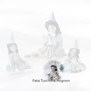 Statua in porcellana della Fata Turchina mignon seduta a terra con codina sulla spalla e stellina sul cappello a punta.