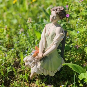 Statua in porcellana di donna in abito verde pastello seduta con mazzo di fiori in grembo, allegoria della Primavera.