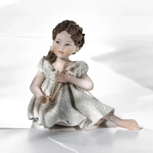 Statua in porcellana di ragazza seduta con abito in pizzo bianco e azzurro e flauto tra le mani.