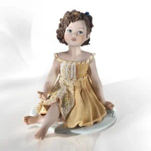 Statua in porcellana Gemelli di Sibania con abito giallo e blu, fiore tra i capelli a caschetto e occhi blu.