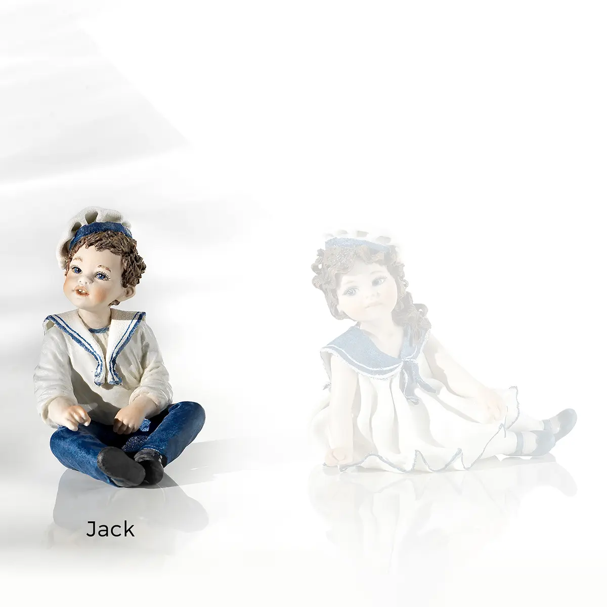 Statua in porcellana Lolly marinaretta con abito bianco bordato di blu, bavero, scarpette blu e baschetto.