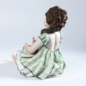 Statua in porcellana di ragazza pensierosa con gatta in grembo e abito verde tè con dettagli verde smeraldo.