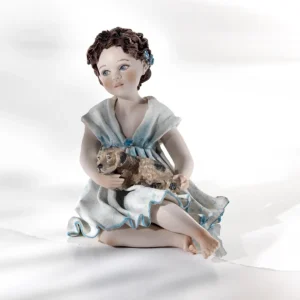 Statua in porcellana con ragazza in abito azzurro e cagnolino marroncino in braccio.