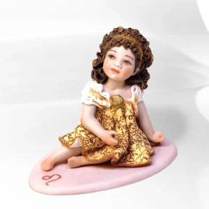 Statua mini Leone in porcellana Sibania con abito in pizzo oro e ocra, fascia dorata e base rossa.
