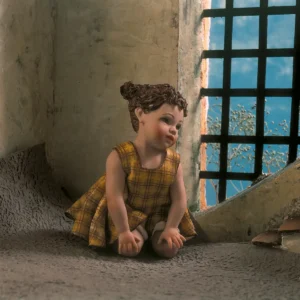 Statue in porcellana di bimba con abito a quadri gialli e bimbo in t-shirt azzurra e maglioncino giallo.