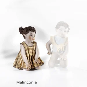 Statua in porcellana Malinconia, bimba in ginocchio con abitino a quadri gialli e due alte codine.