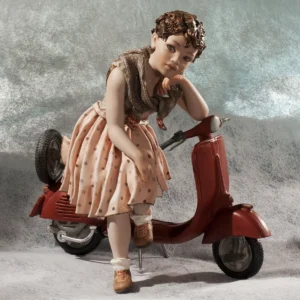 Statua in porcellana di ragazza seduta su Vespa rossa con gonna a pois rosa e maglioncino bruno.