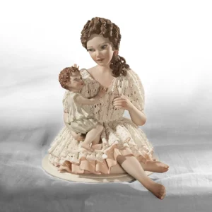 Statua in porcellana di mamma in abito di pizzo rosa con bimbo in braccio rannicchiato sul petto.