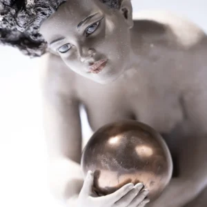 Scultura in gres e metallo raffigurante una donna china che regge un globo sulla mano.