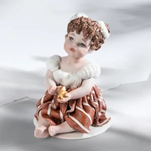 Statua in porcellana Noelle con abito bianco e rosso, stella in mano e chignon con nastri di lana.