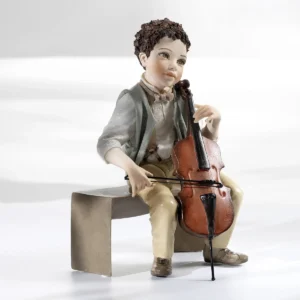 Statua in porcellana di un ragazzo su una panca che suona un piccolo violoncello, con gilet verdino e pantaloni cachi.