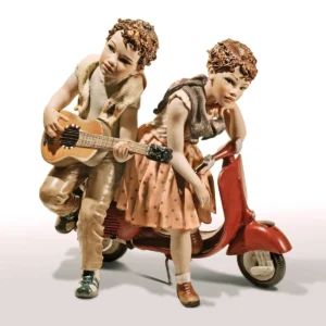 Statua in porcellana con coppia di fidanzati su Vespa rossa, lui suona la chitarra per lei.