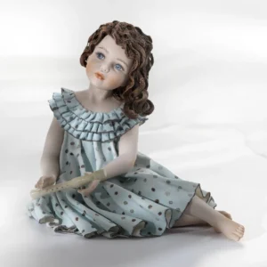 Statua in porcellana di Pamina, ragazza in abito azzurro con flauto e capelli poggiati su una spalla.