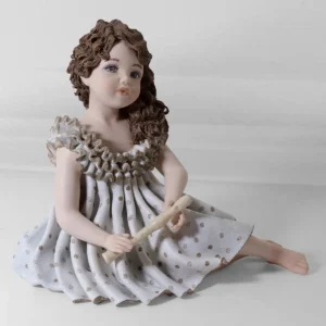 Statua in porcellana di Pamina, ragazza in grazioso abito azzurro con flauto e capelli su una spalla.