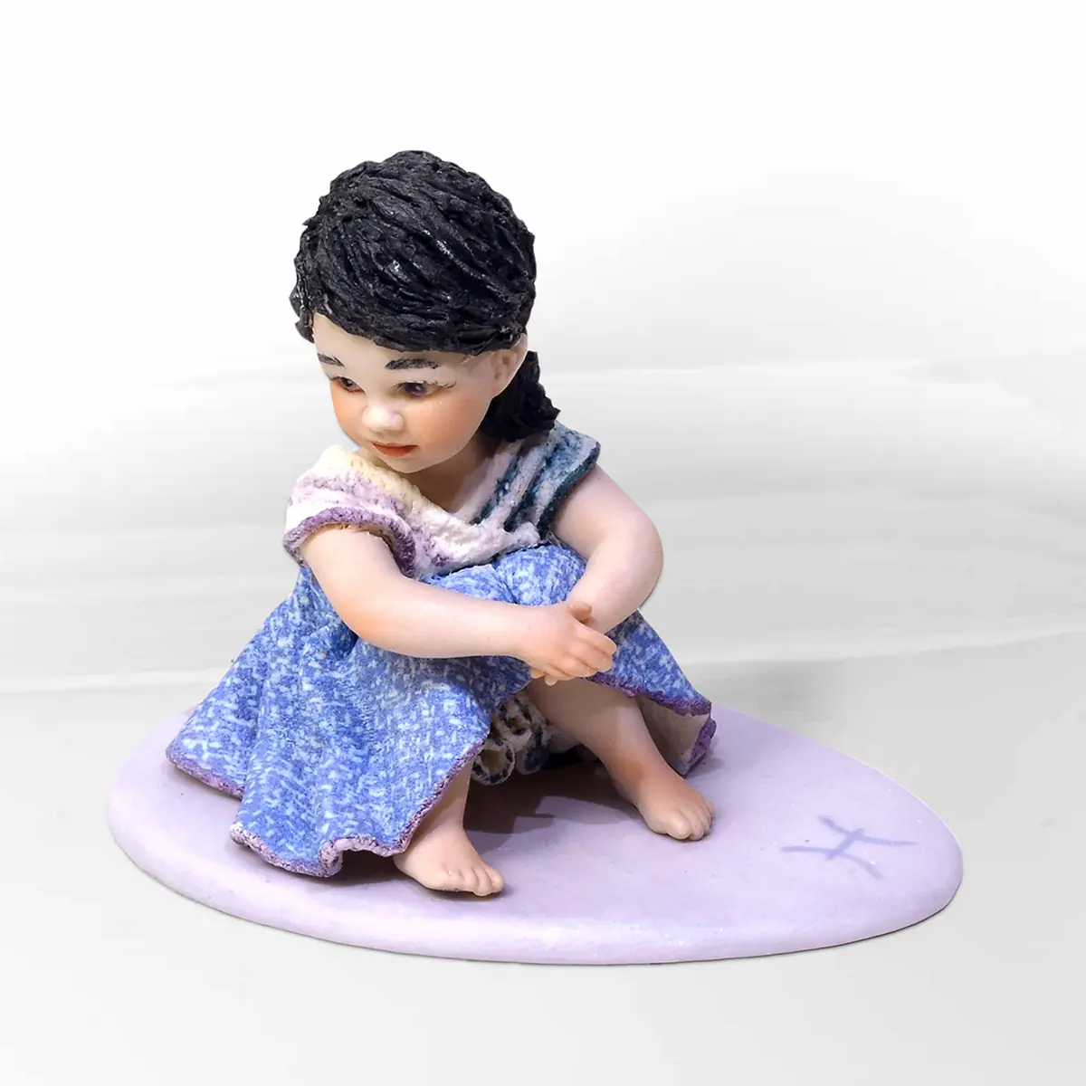 Statua in porcellana mini Pesci di Sibania con abito viola e celeste, dettagli in tulle bianco e capelli neri.
