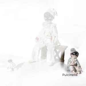 Statua in porcellana di Pulcinella seduto a terra con abito bianco, maschera nera e cornetto rosso portafortuna.