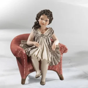 Statua in porcellana di ragazza seduta su poltrona rossa, in abito grigio lavanda con tulle e lunghi capelli neri.