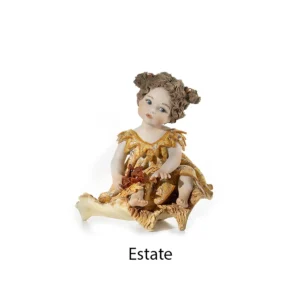 Statua in porcellana dell'Estate con abito a fiori gialli, seduta su fieno con fiori rossi e spighe di grano.