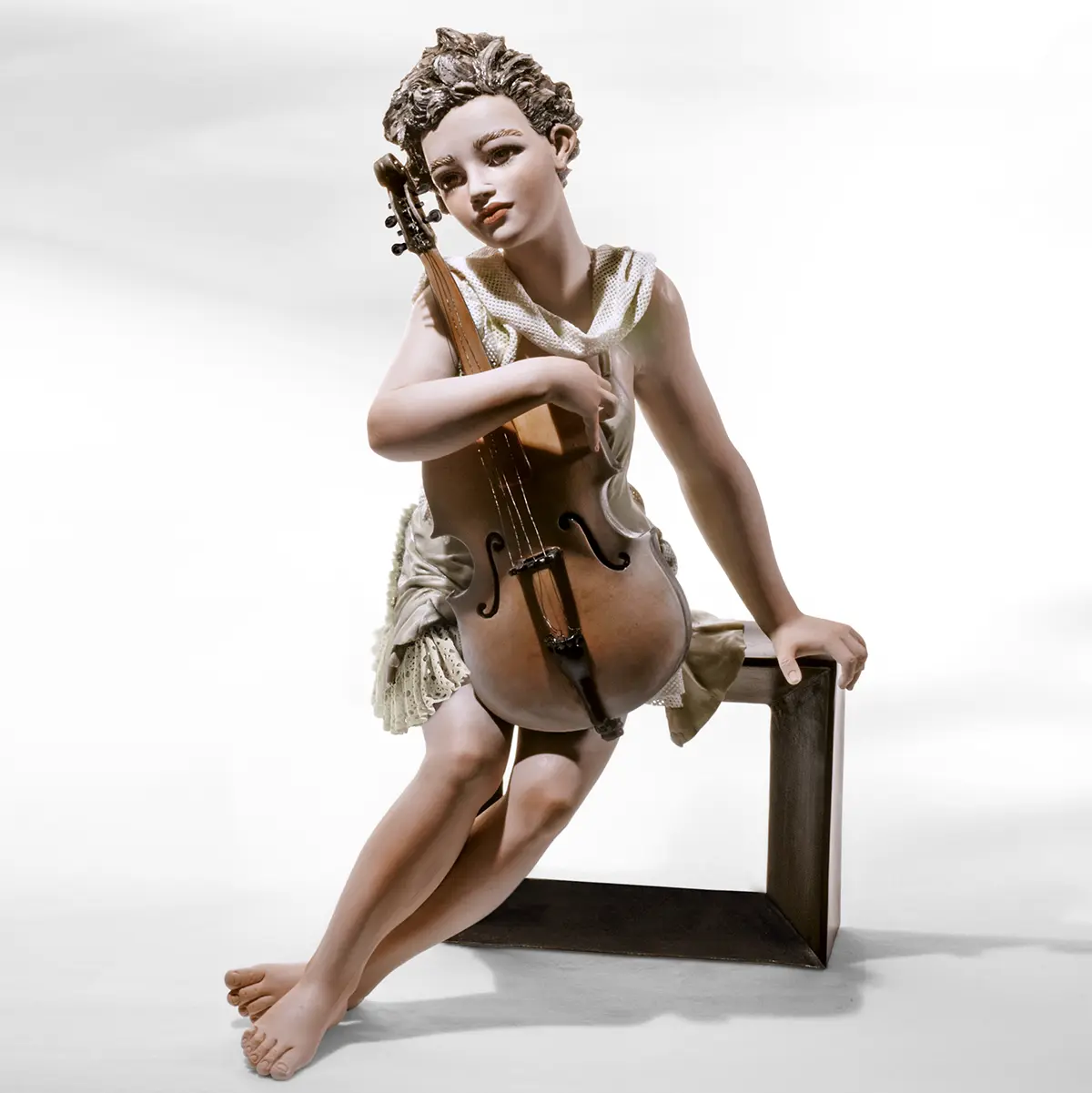 Statua in porcellana di donna seduta su panca nera con violoncello, abito verde pastello e sciarpa di tulle bianco.
