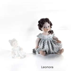 Statua in porcellana Leonora: bimba seduta con abito in pizzo bianco e verde ghiaccio e coda laterale con fiocco.