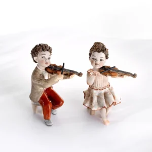 Statue in porcellana Sibania dei piccoli violinisti Vito e Vera in completo marrone e rosa.
