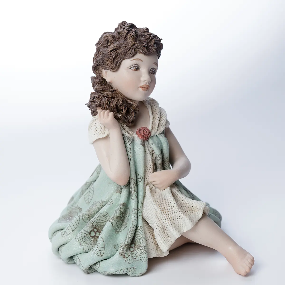 Statua in porcellana Viviana con abito verde menta a palloncino, dettagli in tulle e fiore rosso carminio.